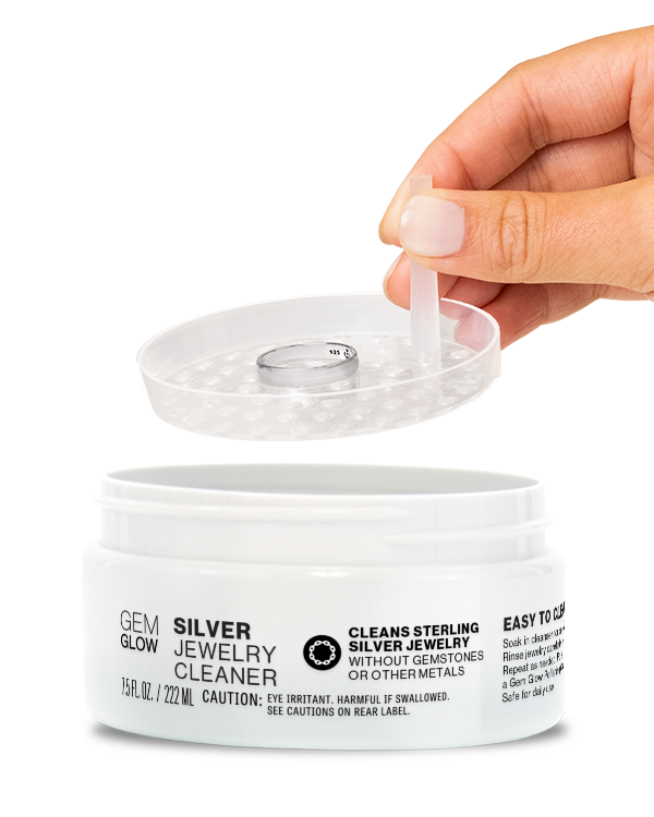 Hand dipping a silver ring into a jar of Silver Jewelry Cleaner